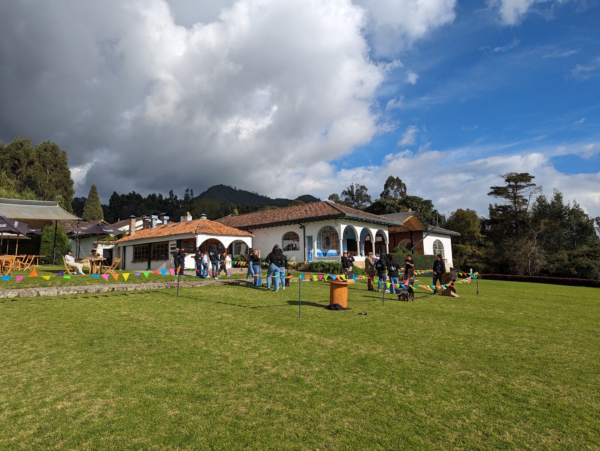 Vista de la propiedad de La Quinta con pasto verde, banderines y personas en actividades de integración